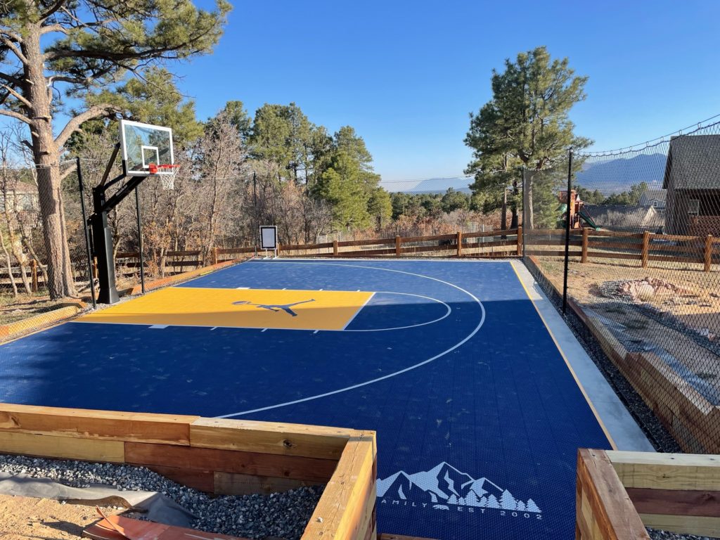 Barrier netting and sports netting installed around a basketball court at a residential location.