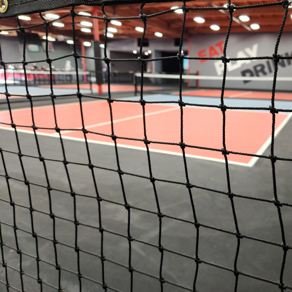 Square mesh twisted-knotted nylon netting for pickleball containment needs.